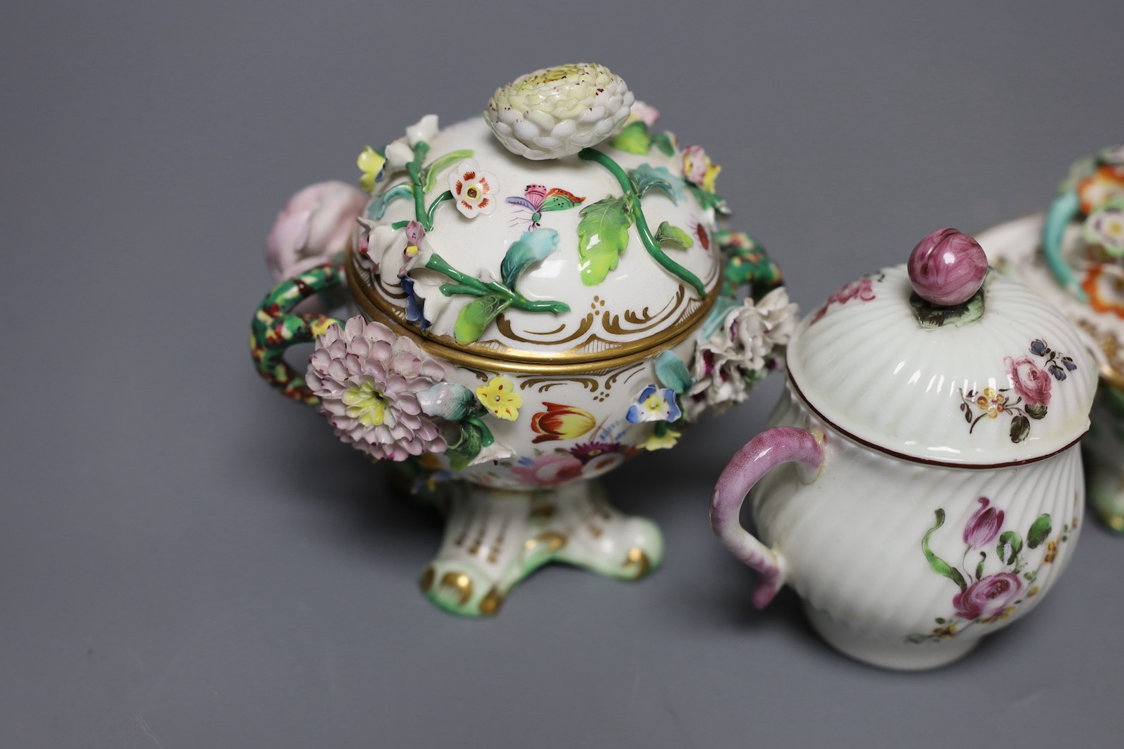 An 18th century Mennecy porcelain cup and cover, a Meissen style cup and cover, an English porcelain floral encrusted double inkwell and cover and a similar jar and cover